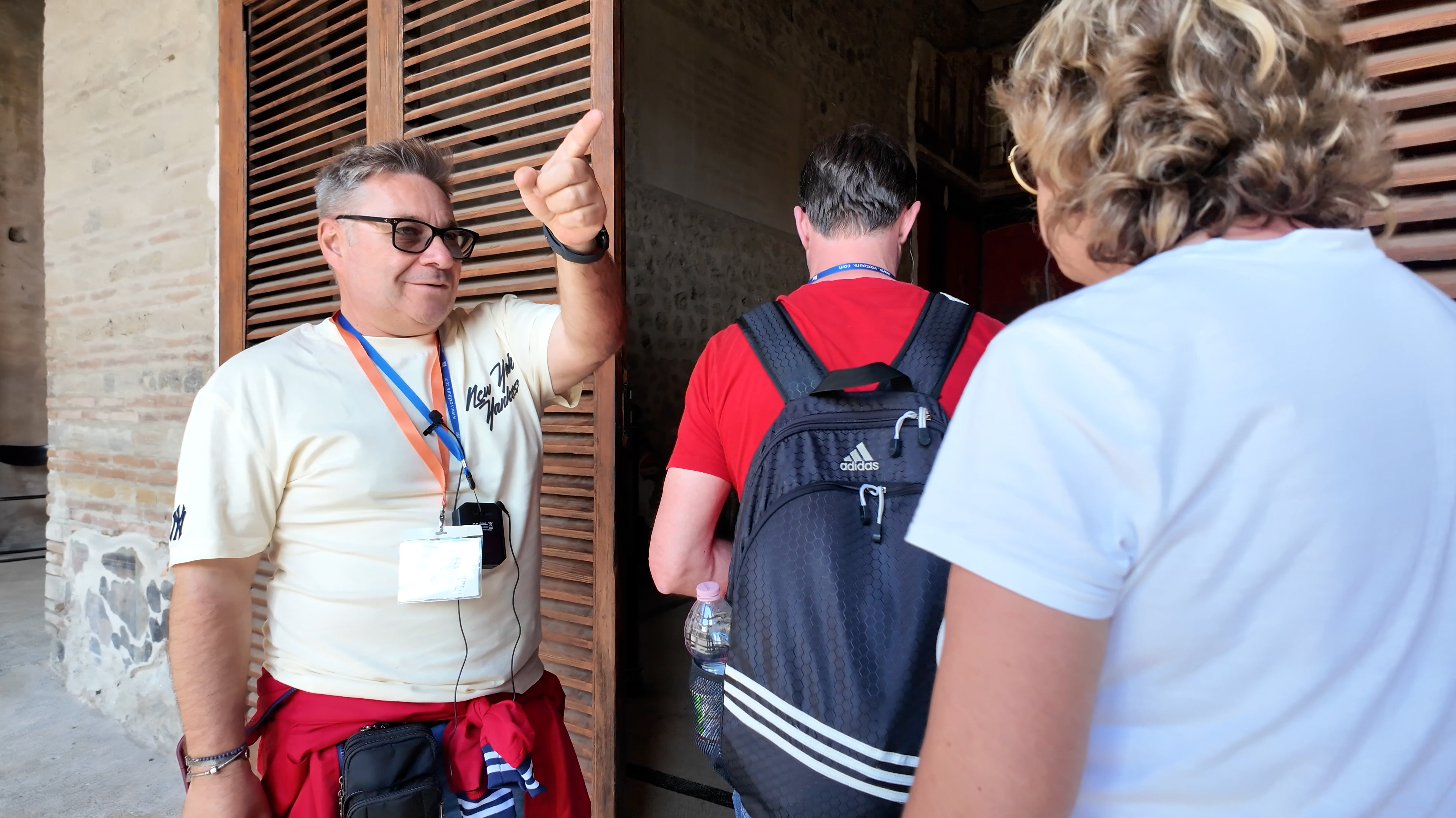Guide leading tourists through Pompeii ruins.