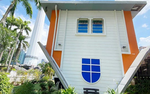 Kuala Lumpur Upside Down House exterior with cityscape in background.