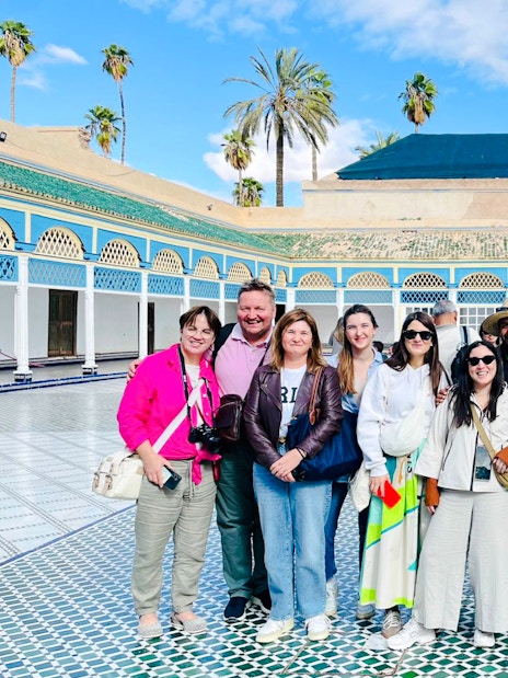 Tourists with a guide in the courtyard of Bahia Palace, Marrakech, Morocco.