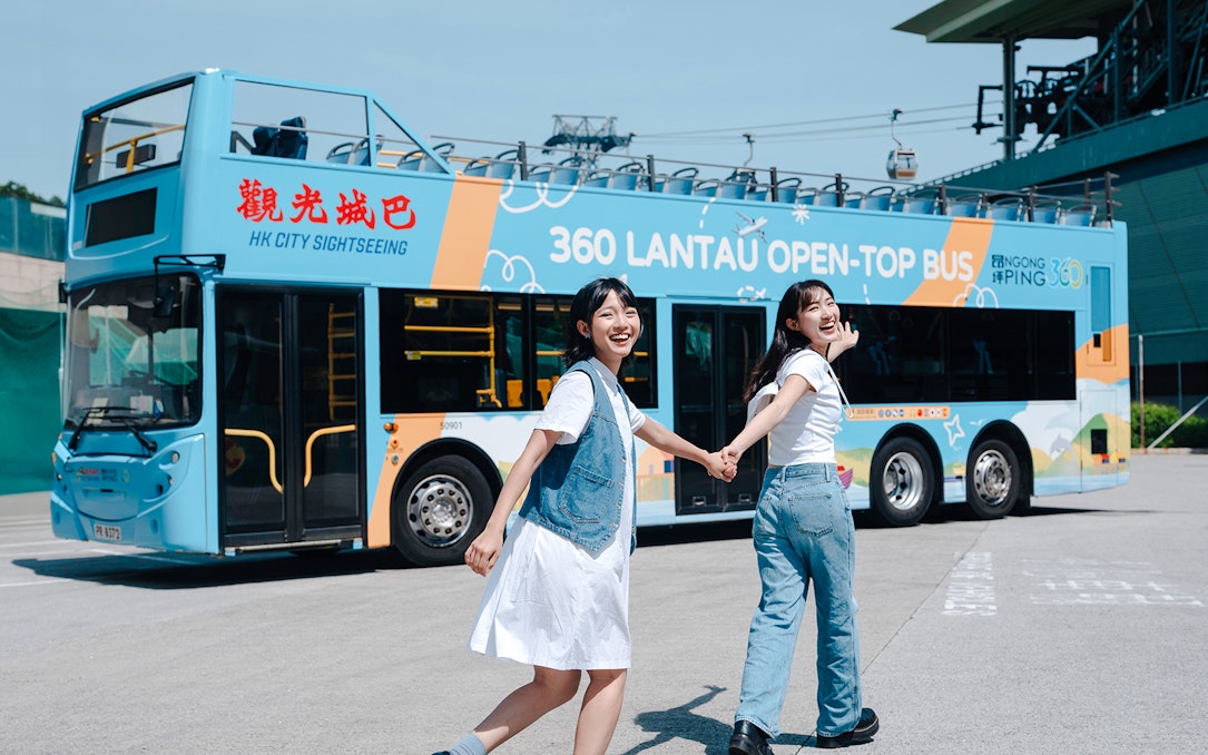 Tourists enjoying Lantau Island hop-on hop-off bus tour in Hong Kong.