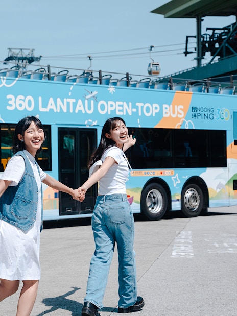 Tourists enjoying Lantau Island hop-on hop-off bus tour in Hong Kong.