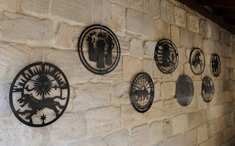 Decorative metal coins displayed on a stone wall at the Museum of Numismatics, Baku.