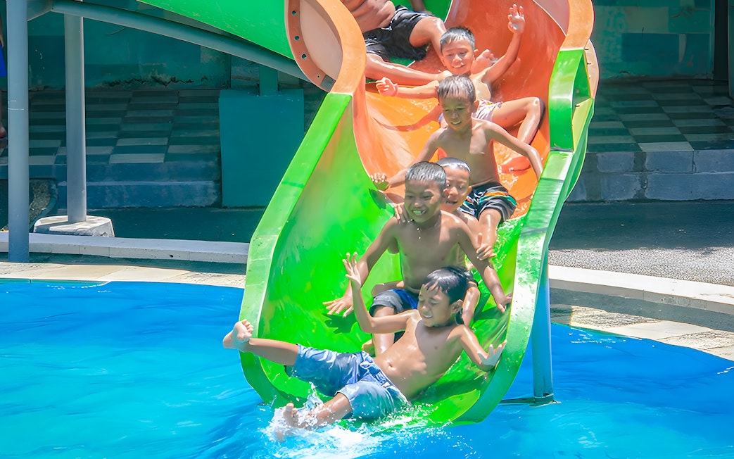 Children enjoying a water slide at Keramas Park, Bali.