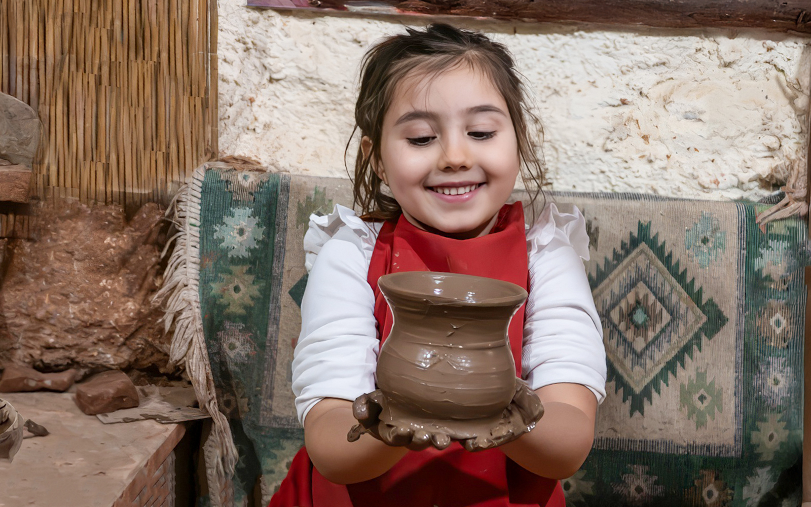 Child holding pottery at Cappadocia workshop.