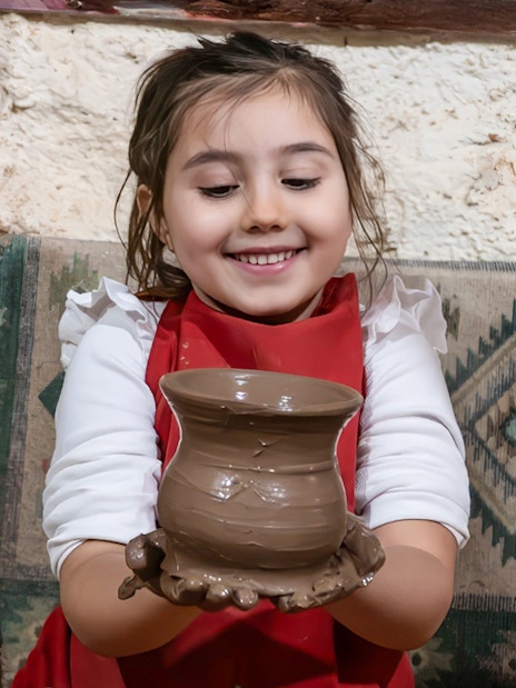Child holding pottery at Cappadocia workshop.