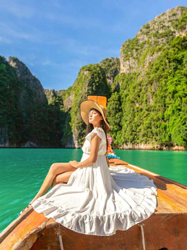 Woman in white dress on longtail boat, Maya Bay tour, Phi Phi Islands.