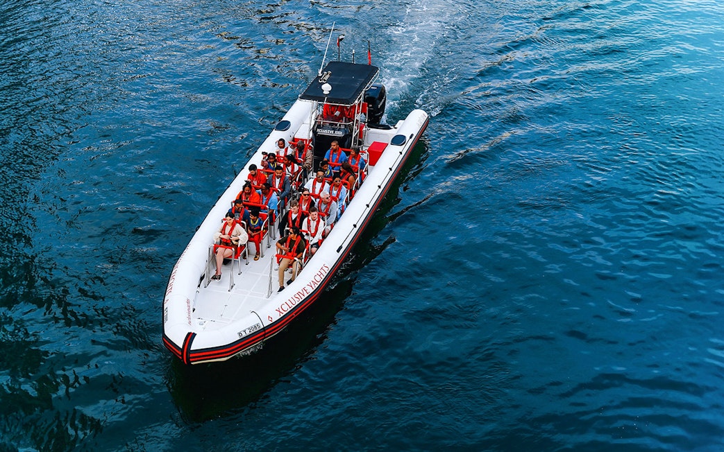 Speedboat with tourists on Dubai Marina tour, heading towards Atlantis and Burj Al Arab.