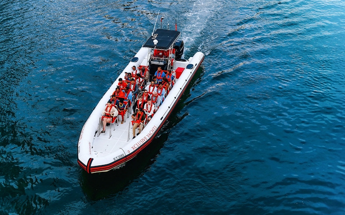 Speedboat with tourists on Dubai Marina tour, heading towards Atlantis and Burj Al Arab.