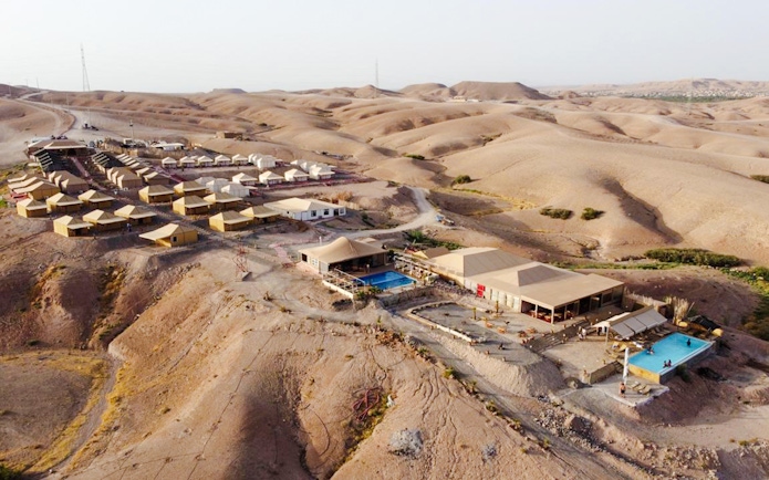 Aerial view of Agafay desert camp near Marrakesh with tents and swimming pool.
