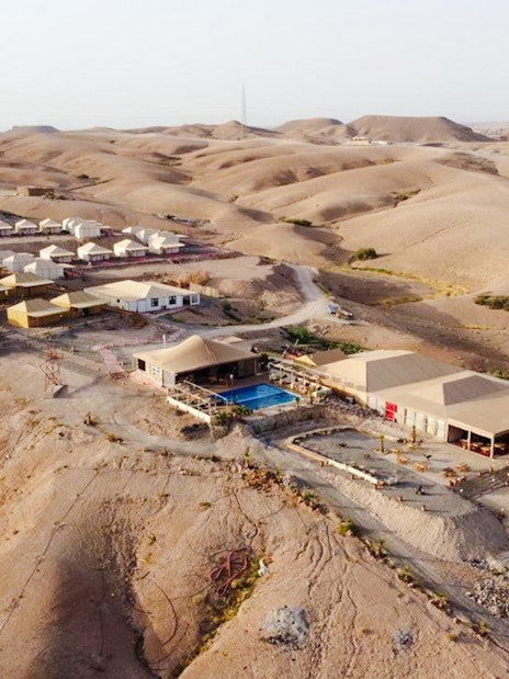 Aerial view of Agafay desert camp near Marrakesh with tents and swimming pool.