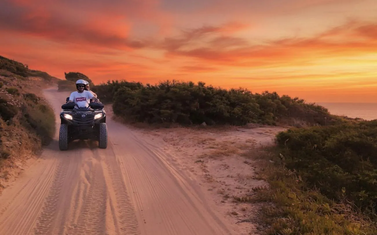 Quad biking at sunset on a sandy trail in Santa Teresa di Gallura, Olbia.
