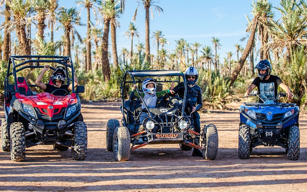 Quad bikes and dune buggies in the Palmeraie desert landscape during a sunset tour.