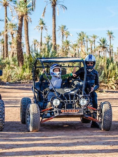 Quad bikes and dune buggies in the Palmeraie desert landscape during a sunset tour.