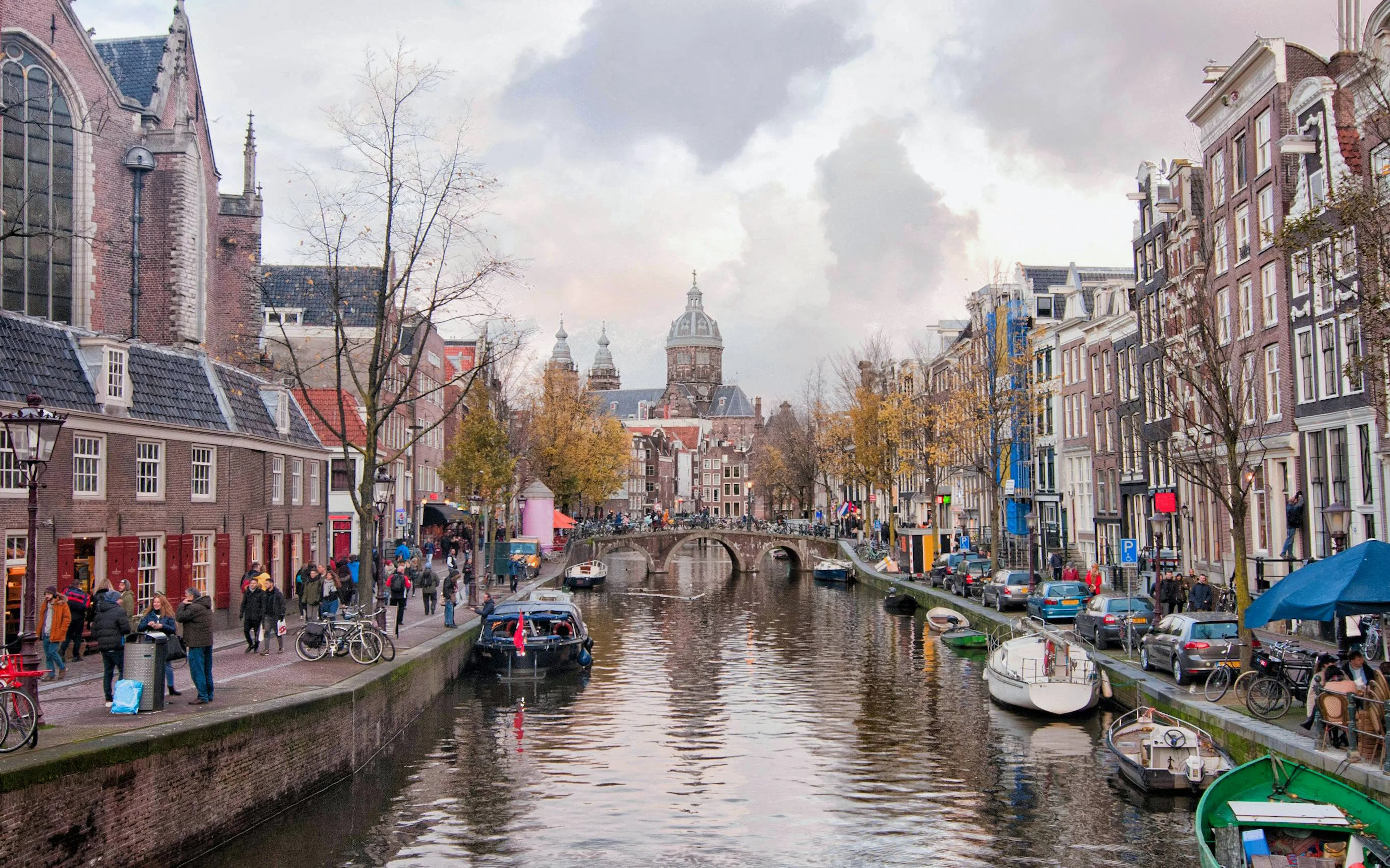 Oudezijds Voorburgwal canal with boats and historic buildings in Amsterdam.