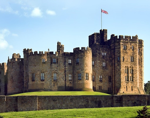 Alnwick Castle exterior with stone walls and towers in Northumberland, England.