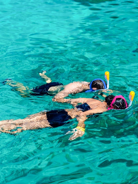 Two people snorkeling in clear Surin Islands waters.