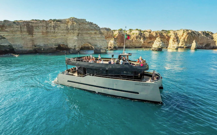 Boat tour near Benagil Caves, Vilamoura, with passengers enjoying the view.
