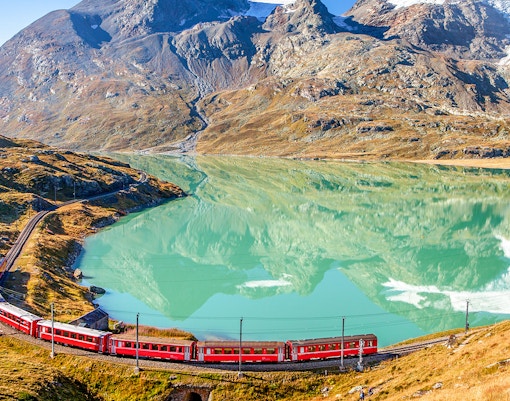 Glacier Express during spring season in front of a blue clear meadow