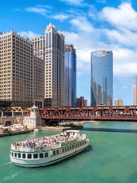 Tour boat on the Chicago River with downtown Chicago skyscrapers in the background.