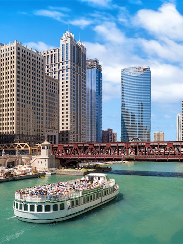 Tour boat on the Chicago River with downtown Chicago skyscrapers in the background.