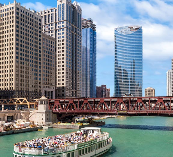 Tour boat on the Chicago River with downtown Chicago skyscrapers in the background.