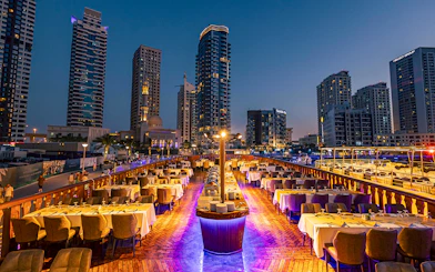Dhow cruise dinner setup with cityscape view at Dubai Marina.