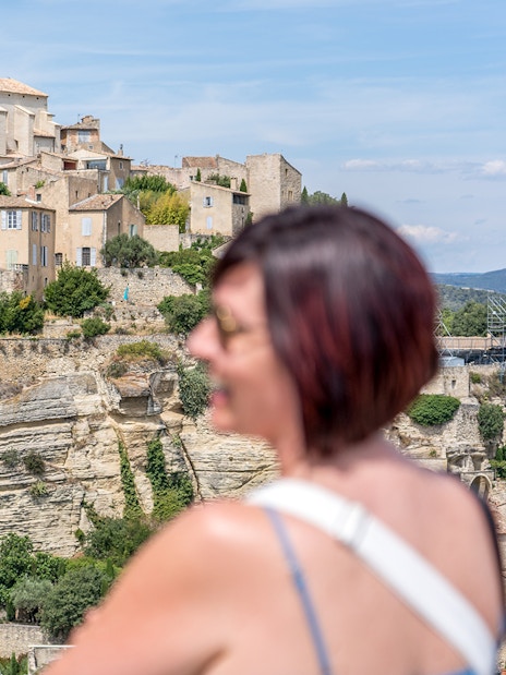 Provence village view with historic stone buildings and tourists in foreground.