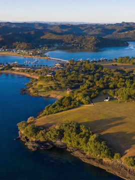 Aerial view of Waitangi Treaty Grounds, lush greenery and coastline in New Zealand.