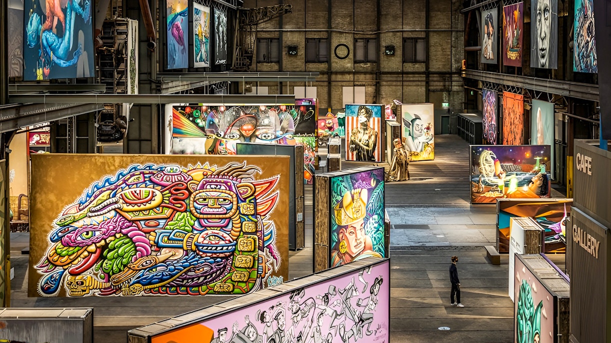 STRAAT Museum exterior with vibrant street art and Amsterdam canal cruise boat.
