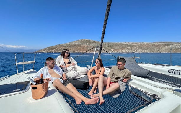 Catamaran cruise in Heraklion with guests relaxing on deck, enjoying the sea view.