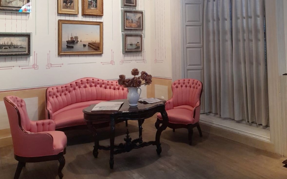 Seating area with pink chairs and paintings inside Picasso's birthplace museum in Malaga.