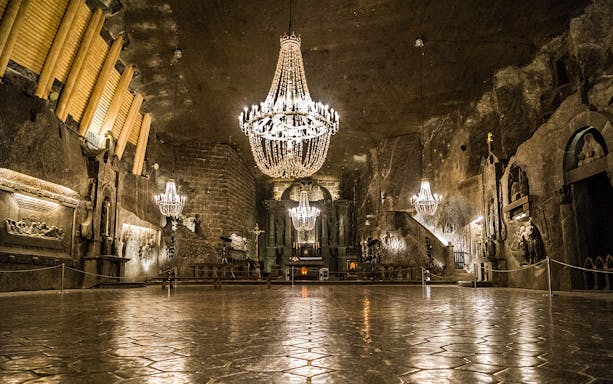 Wieliczka Salt Mine cathedral with chandeliers and carved salt walls.