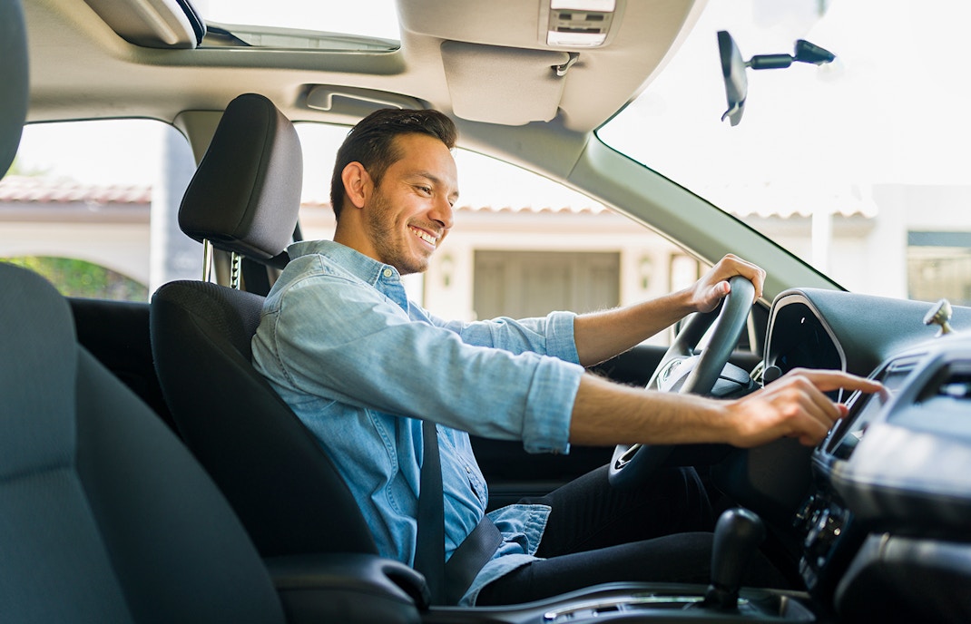 Male driver using GPS navigation in car to reach Kuranda Village, Australia.