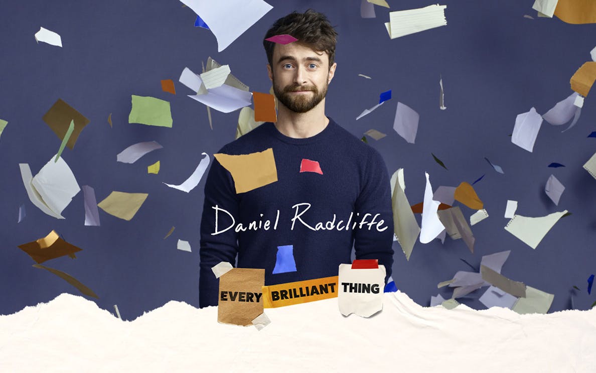 Actor surrounded by colorful paper pieces, promoting Every Brilliant Thing Broadway show.