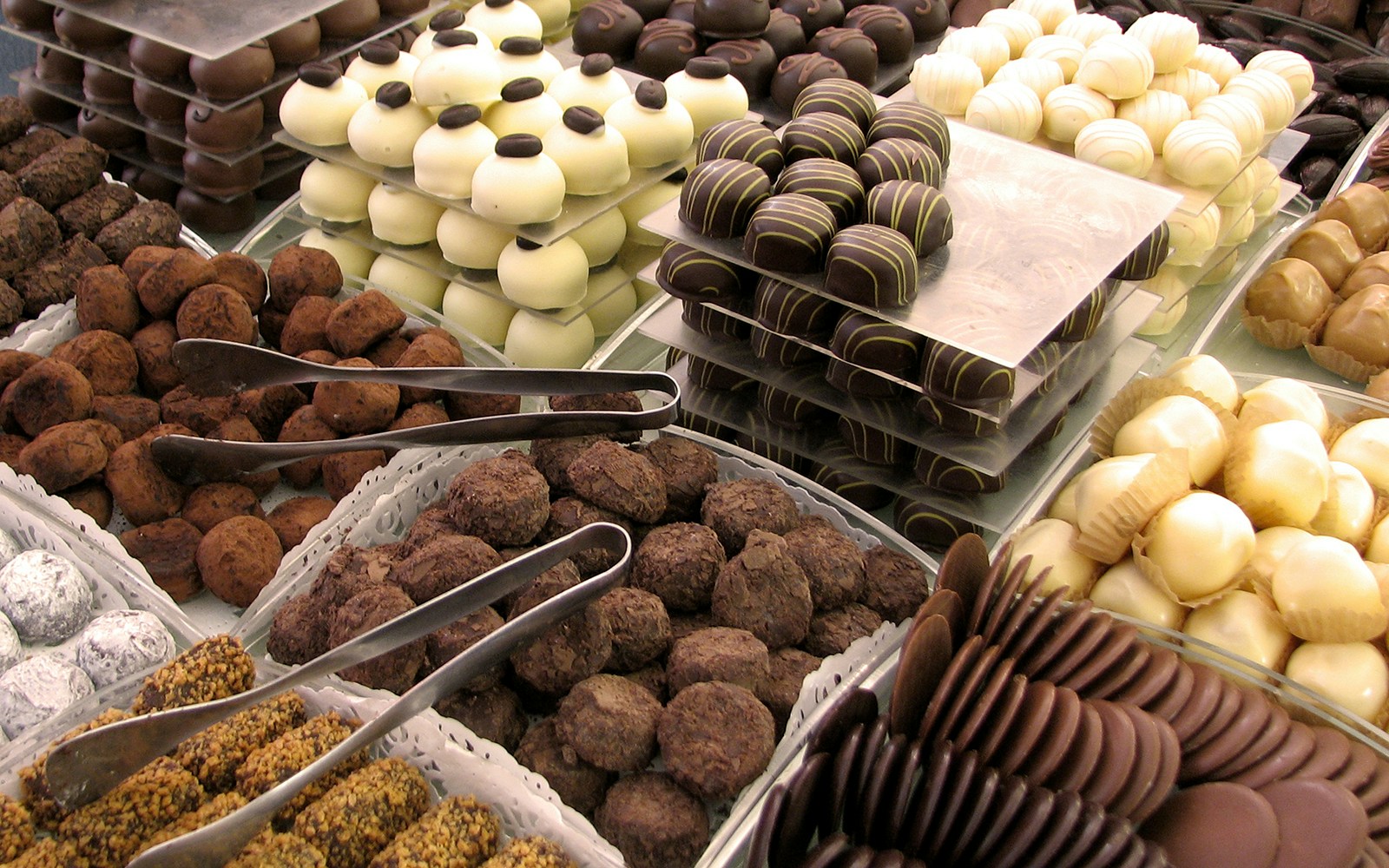 Assorted chocolates displayed at a renowned chocolatier in Bruges, featuring a variety of truffles and pralines.