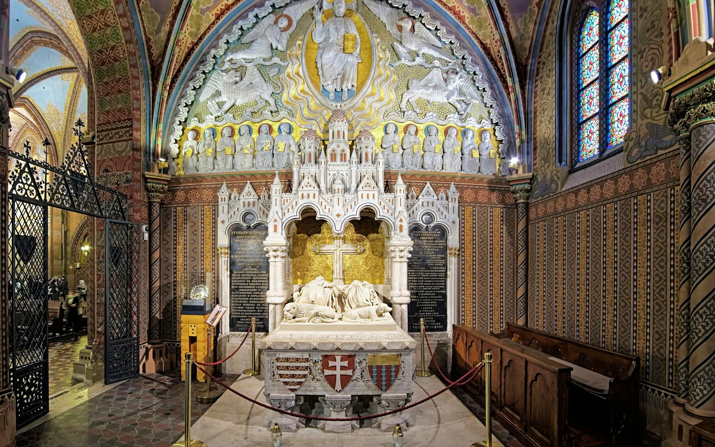 Interior of Matthias Church in Budapest with ornate altar and stained glass windows.