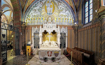 Interior of Matthias Church in Budapest with ornate altar and stained glass windows.