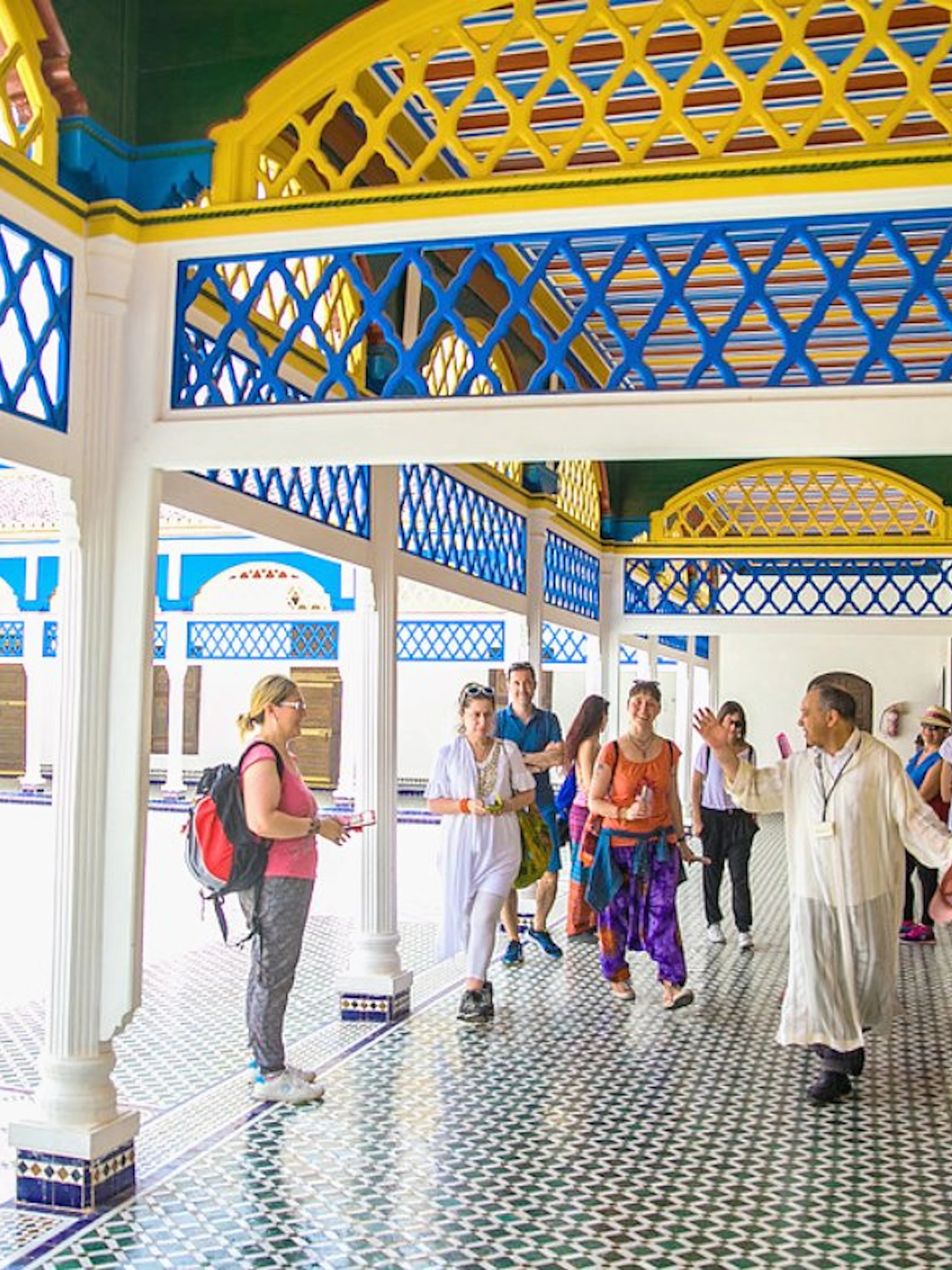 Tour group exploring Bahia Palace courtyard in Marrakech.