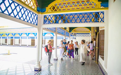 Tour group exploring Bahia Palace courtyard in Marrakech.