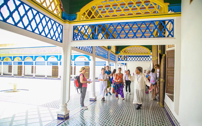 Tour group exploring Bahia Palace courtyard in Marrakech.