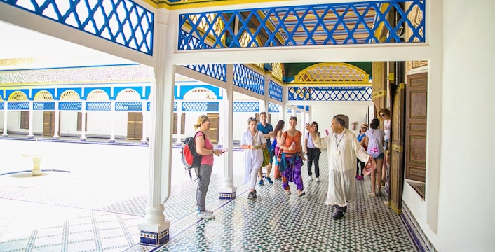 Tour group exploring Bahia Palace courtyard in Marrakech.