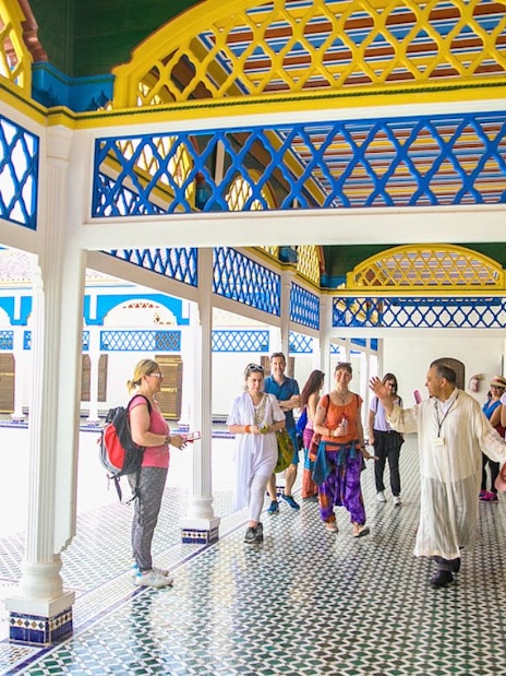 Tour group exploring Bahia Palace courtyard in Marrakech.