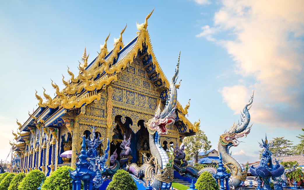 Wat Rong Suea Ten temple with intricate blue and gold architecture in Chiang Rai, Thailand.