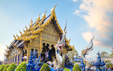 Wat Rong Suea Ten temple with intricate blue and gold architecture in Chiang Rai, Thailand.