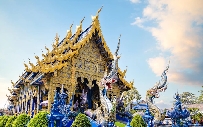 Wat Rong Suea Ten temple with intricate blue and gold architecture in Chiang Rai, Thailand.