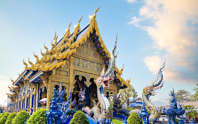 Wat Rong Suea Ten temple with intricate blue and gold architecture in Chiang Rai, Thailand.