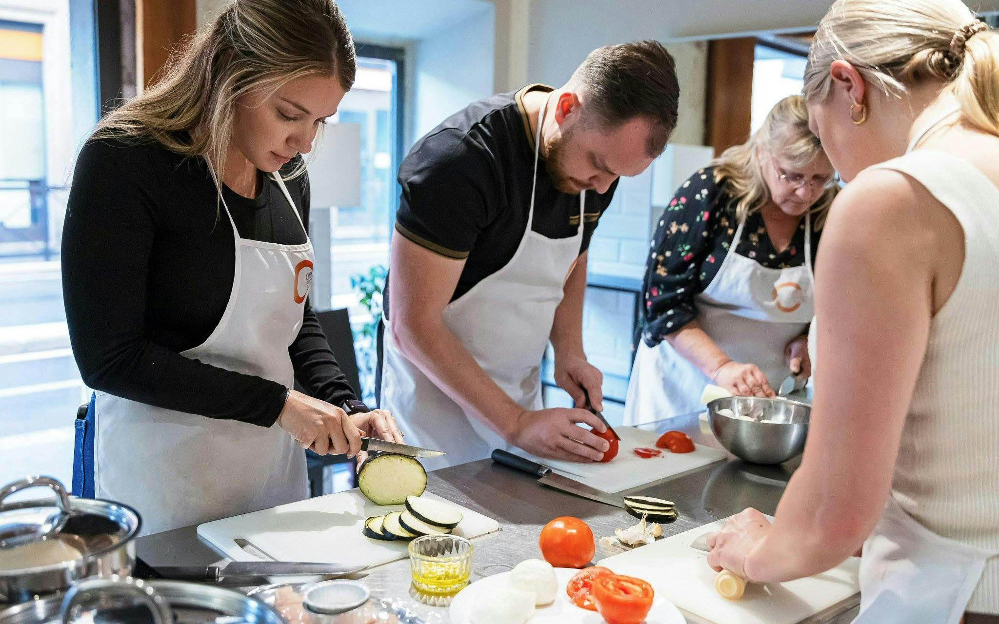 Small group preparing ingredients in a cooking class in Florence.