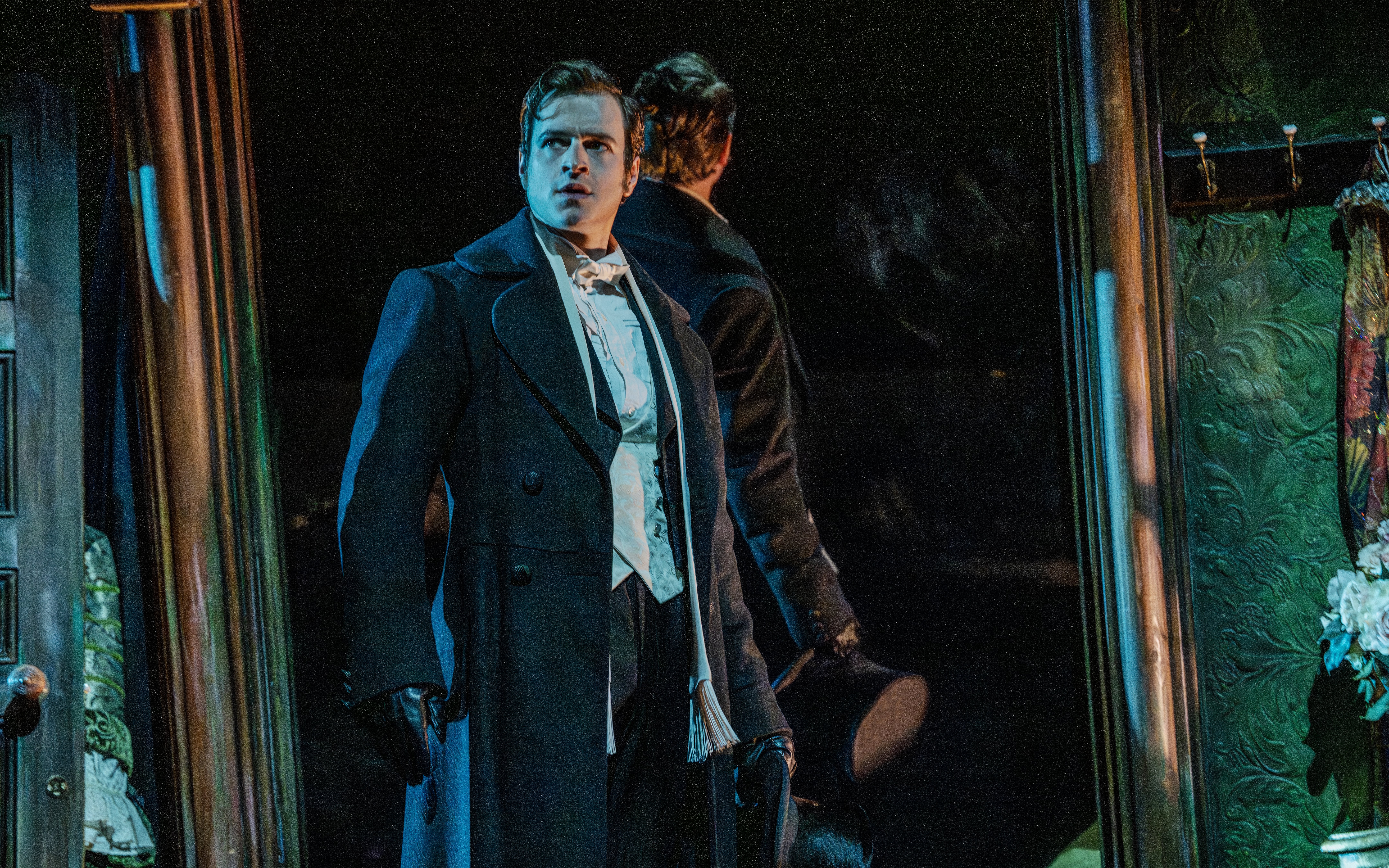 Actor in Victorian attire on stage during Phantom of the Opera production.