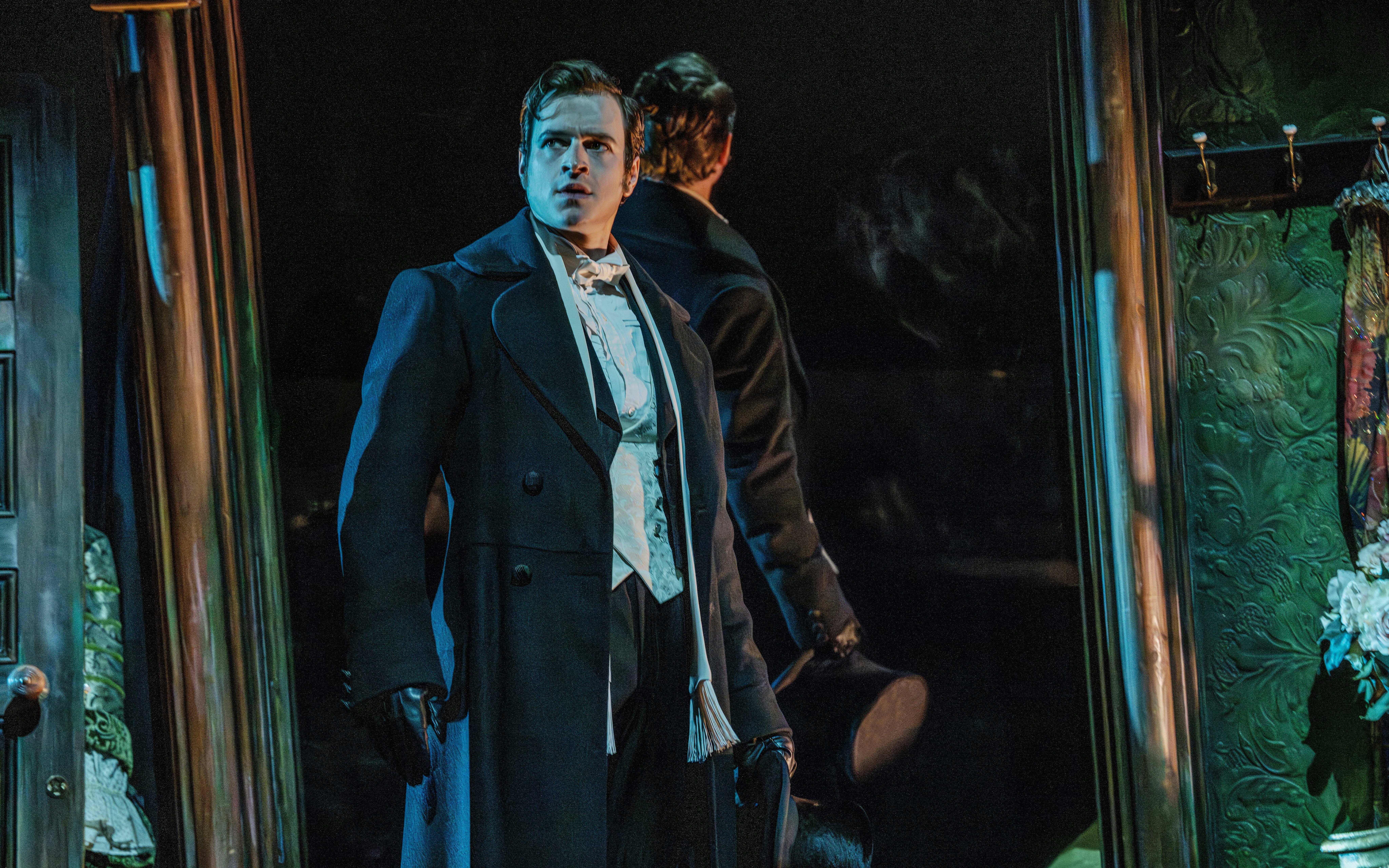 Actor in Victorian attire on stage during Phantom of the Opera production.