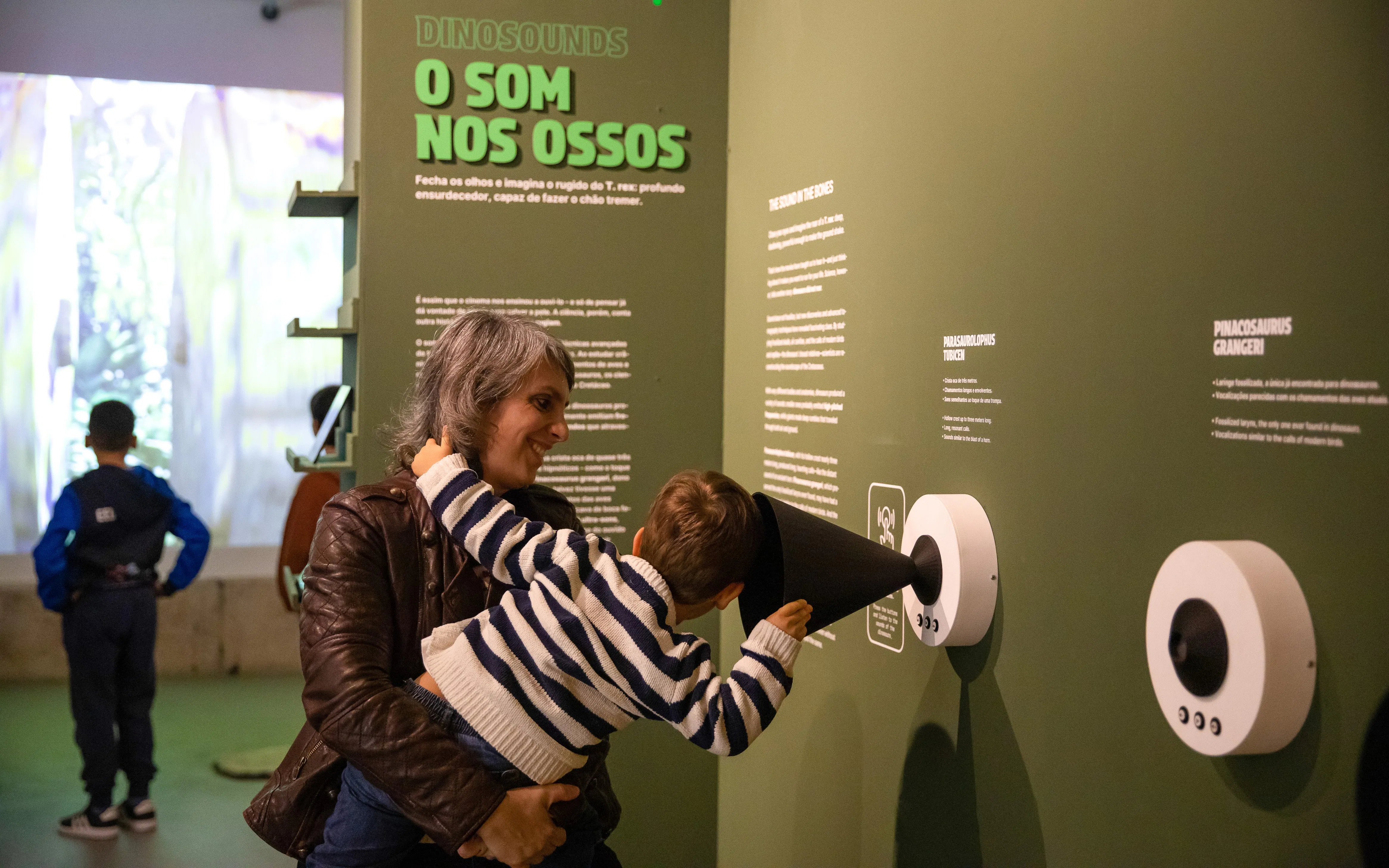 Tourists interacting with sound exhibit at Dino Experience Porto.